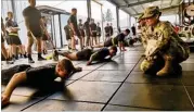  ?? STEPHANIE SLATER / U.S. ARMY ?? Sgt. 1st Class Kimberlee Hilliard, a master fitness trainer, observes for proper form as soldiers in the 2nd Battalion, 7th Ranger Regiment at Joint Base Lewis-McChord in Washington perform T pushups.