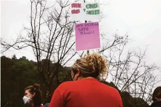  ?? Jessica Christian / The Chronicle ?? Oakland teachers gather at Leona Canyon Trailhead to decorate their cars before participat­ing in a car caravan protest on Jan. 7. Teachers called a second sickout on Thursday as the omicron variant surges.