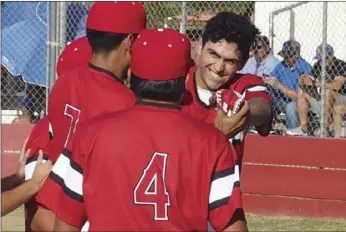  ?? KARINA LOPEZ PHOTO ?? Imperial High’s Diego Mellos is mobbed by teammates after scoring on a wild pitch in the Tigers’ game on Tuesday afternoon.