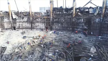  ?? (Russian Emergencie­s Ministry/Reuters) ?? WORKERS REMOVE debris inside the burnt-out Crocus City Hall following last week’s deadly attack on the concert venue outside Moscow.