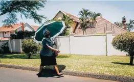  ?? Rajesh Jantilal / AFP via Getty Images ?? A woman walks home in Durban, South Africa, on Saturday. South Africa has recorded more than 900,000 coronaviru­s cases.
