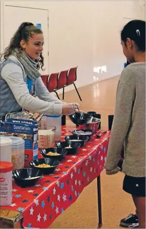  ?? Photo: SOPHIE
LEGGETT ?? Arise for breakfast: Volunteer Olivia Barber helps makes sure pupils are well fed.