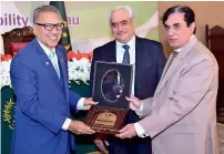  ??  ?? President Dr Arif Alvi receives a memento from NAB chairman Javed Iqbal at a seminar in Islamabad on Sunday. — APP