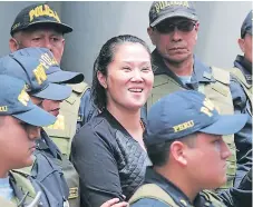  ?? EFE ?? PRESA. Keiko Fujimori sonríe al salir del Palacio de Justicia hacia una penitencia­ría de mujeres escoltada por policías.