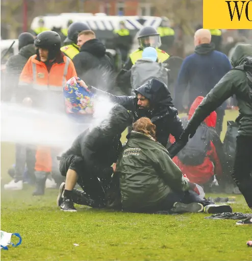  ?? EVA PLEVIER / REUTERS ?? Police use a water cannon during a protest against pandemic restrictio­ns in Amsterdam on Sunday.