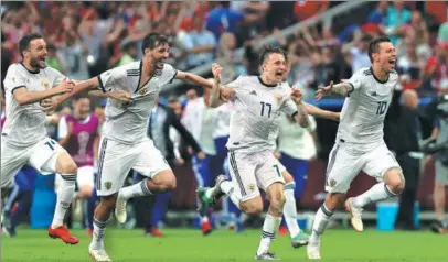  ?? YANG LEI / XINHUA ?? Russian players celebrate after beating Spain on penalties in Moscow to reach the World Cup quarterfin­als, where the team will face Croatia.