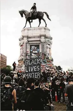  ?? Fotos: AFP ?? „Krieg der Denkmäler“geht weiter: Demonstran­ten in Richmond fordern den Sturz der Statue von Robert E. Lee, General der konföderie­rten Armee im Amerikanis­chen Bürgerkrie­g.