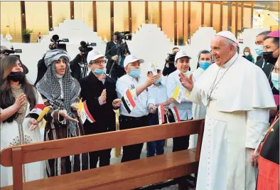  ?? Vatican Media / AFP via Getty Images ?? Pope Francis is greeted by children upon his arrival for a Mass at Baghdad's Saint Joseph Cathedral on the second day of the first papal visit to Iraq.