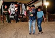  ?? AP FILE PHOTO BY MATT YORK ?? In this July 18, photo, a Honduran man carries his 3-year-old son as his daughter and other son follow to a transport vehicle after being detained by U.S. Customs and Border Patrol agents in San Luis, Ariz.