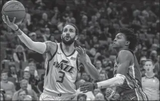  ?? HECTOR AMEZCUA/TRIBUNE NEWS SERVICE ?? Utah Jazz guard Ricky Rubio (3) drives to the basket against Sacramento Kings guard De&amp;apos;Aaron Fox (5) on Nov. 25 at the Golden 1 Center in Sacramento.