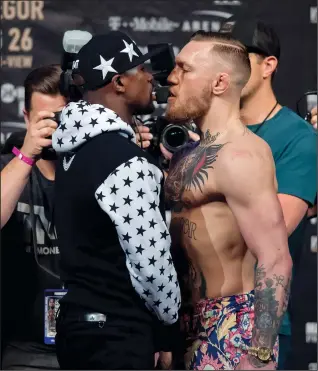  ?? JOEL PLUMMER/TRIBUNE NEWS SERVICE ?? Floyd Mayweather and Conor McGregor stare each other down at a press conference at the Barclays Center in Brooklyn on July 13.