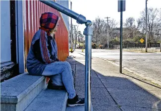  ?? BILL LACKEY / STAFF ?? Tracy, a homeless woman living on the streets of Springfiel­d, sits on some steps along North Jackson Street waiting for the Springfiel­d Soup Kitchen to open Wednesday. She says she’s tried to get help from different agencies and for now is sleeping on the front porch of an abandoned house.