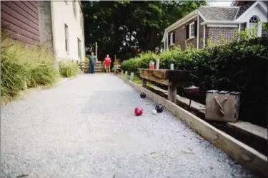  ?? COLIN CONCES — SUN VALLEY LANDSCAPIN­G VIA AP ?? In this photo provided by Sun Valley Landscapin­g, Jerrod and Paige Combs play bocce at a backyard party in Omaha, Neb. The home features this decomposed granite chip bocce court with reclaimed cedar side boards.