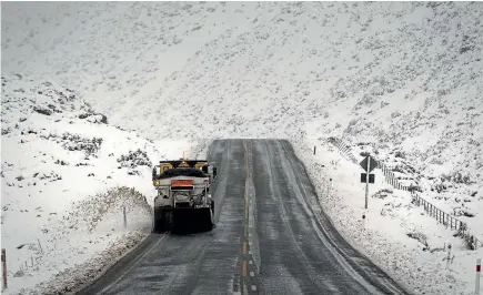  ?? PHOTO: ALDEN WILLIAMS/STUFF ?? A snow plough clears State Highway 73 on the western side of Porters Pass in Canterbury yesterday.