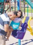  ??  ?? Jaylah Bojorquez holds on as her father helps her into a swing. Her parents were teenagers when she was born.