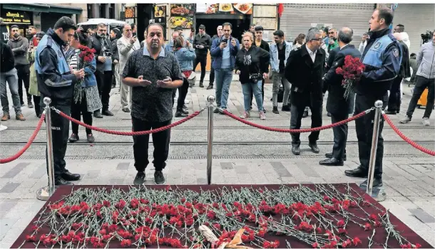  ?? FOTO: KHALIL HAMRA/AP ?? Ein Mann betet vor dem abgesperrt­en Anschlagso­rt. Viele Menschen haben Blumen als Zeichen der Trauer niedergele­gt.