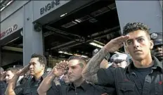  ?? Mark Lennihan/Associated Press ?? New York City firefighte­rs with Ladder 10 Engine 10 firehouse salute during a moment of silence at the World Trade Center in New York.