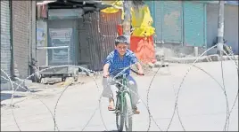  ?? WASEEM ANDRABI/HT ?? A Kashmiri boy rides his bicycle during the curfew in Srinagar.