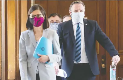  ?? JACQUES BOISSINOT/THE CANADIAN PRESS ?? Quebec Health Minister Danielle Mccann, left, Premier François Legault, and Horacio Arruda, Quebec director of public health, walk to a news conference on the COVID-19 pandemic wearing masks on Tuesday. Wearing masks is “a good practice,” Legault said.