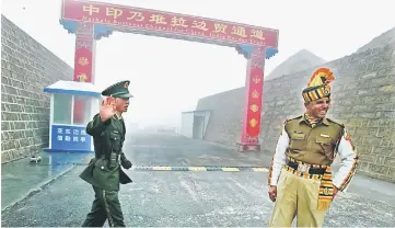  ??  ?? File photo shows a Chinese soldier (left) next to an Indian soldier at the Nathu La border crossing between India and China in India’s northeaste­rn Sikkim state. — AFP photo