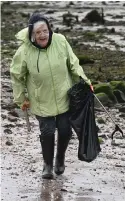  ?? ?? The wet and windy conditions didn’t deter volunteers from picking up rubbish along the shores