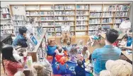  ?? Submitted Photo ?? Brittany Mangold, clerk at the Gravette Public Library, reads the storybook, “Good Night, Moon,” during a special storytime session for youngsters at the library’s Moon Over Main Street event Saturday evening, Oct. 1.