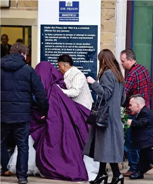  ??  ?? Shrouded: Miss Williamson enters the prison under a purple blanket