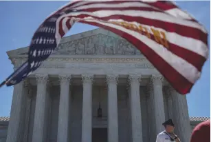  ??  ?? A MAN HOLDS a flag outside the US Supreme Court on Monday.