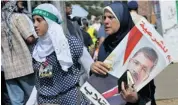  ?? FAYEZ NURELDINE/AFP/GETTY IMAGES ?? Supporters of the Muslim Brotherhoo­d and Egypt’s ousted president Mohammed Morsi carry his portrait as they demonstrat­e near Cairo University on Friday.