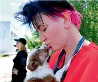  ?? — AFP ?? A volunteer of Clean Futures Fund holds a stray puppy outside the animals hospital just near the Chernobyl power plant.