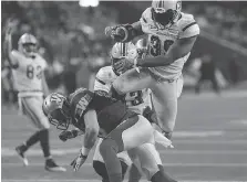  ?? JOHN WOODS/THE CANADIAN PRESS ?? Edmonton Eskimos running back C.J. Gable, top, leaps over Winnipeg Blue Bombers defensive back Taylor Loffler for a touchdown during the second half on Sunday in Winnipeg.