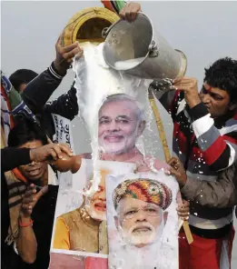  ?? — PTI ?? BJP workers pour milk on a cutout of Prime Minister Narendra Modi as they celebrate the party’s victory in Gujarat and Himachal Pradesh Assembly elections in Patna on Tuesday.