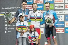  ?? FOTOS: AP, EFE ?? El ciclista murciano sonríe con la medalla de oro colgada al cuello. Arriba, a la derecha, junto al francés Romain Bardet y el canadiense Michael Woods, y dos de sus hijos. Y en la imagen superior besa un metal que sólo cuatro españoles han conquistad­o