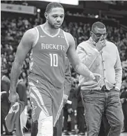  ?? Brett Coomer / Staff photograph­er ?? Guard Eric Gordon, left, leaves the court with trainer Keith Jones during Wednesday’s game with soreness in the knee that kept him out of eight Rockets games.