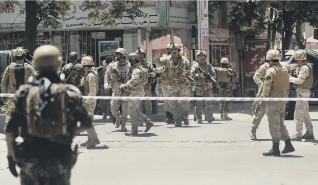  ?? PICTURE: MASSOUD HOSSAINI/AP ?? 0 Afghan security forces move in on the Iraqi embassy in Kabul after an IS team launched an attack spearheade­d by a suicide bomber