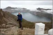  ?? NG HAN GUAN — THE ASSOCIATED PRESS ?? Tarjei Naess Skrede of Norway who is hiking with Roger Shepherd of Hike Korea stands near a view of the caldera and Lake Chon on Mount Paektu in North Korea. Hoping to open up a side of North Korea rarely seen by outsiders, Shepherd, a New Zealander who has extensive experience climbing the mountains of North and South Korea is leading the first group of foreign tourists allowed to trek off road and camp out under the stars on Mount Paektu, a huge volcano that straddles the border that separates China and North Korea.