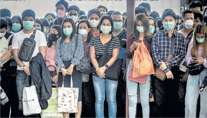  ?? AFP ?? Prevención. Pasajeros en Bangkok (Tailandia) aguardan la llegada de un barco para atravesar uno de los canales de la ciudad. El uso de máscaras es cotidiano en países asiáticos.