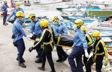  ??  ?? Firemen carry a body recovered near the Sai Kung Hoi Pong Street waterfront in Hong Kong. — Reuters photo