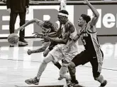  ?? Ronald Cortes / Contributo­r ?? Spurs guards Patty Mills, left, and Keldon Johnson stop the Raptors’ Pascal Siakam from scoring in the final minute of play at the AT&T Center.