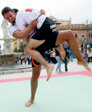  ??  ?? Muscoli e sorrisi Sopra, un incontro di lotta in piazza delle Erbe I punti per giocare sono tantissimi (Sartori)