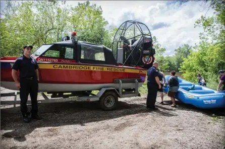  ?? VANESSA TIGNANELLI, THE RECORD ?? Cambridge Fire and Rescue’s Tim Guenther, left, and Rick Pynn return an air rescue boat after a false alarm Monday afternoon on the Grand River, where an unattended dinghy was spotted.