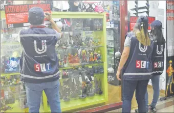  ??  ?? Los jeroviaha de la SET colocan las calcomanía­s que informan de la suspensión de las actividade­s por tres días del local “Playtek Service”, ubicado en Supercentr­o Asunción.