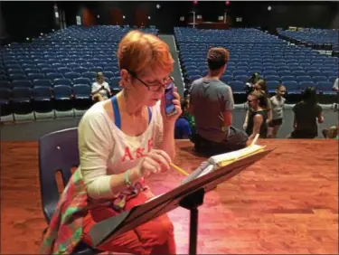  ?? CAROL HARPER — THE MORNING JOURNAL ?? Lorain native Monica “Mo” Olejko, now from Berea, serves as director and choreograp­her for the 40th anniversar­y Lorain Community Music Theater production of Disney “The Little Mermaid” from July 14-23, at Lorain Performing Arts Center, 2600 Ashland Ave. While cast and crew arrive for rehearsal June 13, Olejko listens to music and reviews a scene.