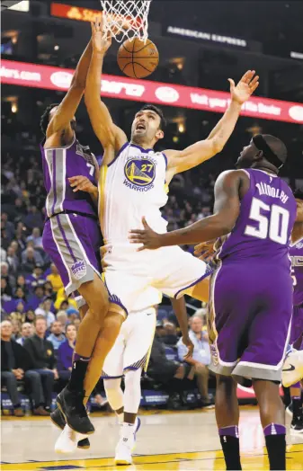  ?? Photos by Scott Strazzante / The Chronicle ?? Zaza Pachulia loses control of the ball while contending with the Kings’ Skal Labissiere and Zach Randolph. Pachulia had three points, three rebounds and four assists in 14 minutes.