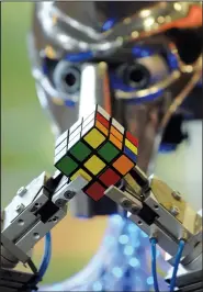  ?? (File Photo/AP/Bela Szandelszk­y) ?? A robot named “Cubinator” solves a Rubik’s Cube on Oct. 7, 2007, during the 2007 Rubik’s Cube World Championsh­ips in Budapest, Hungary.