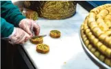  ??  ?? Tamem Al-Sakka is seen working in his pastry shop, ‘Konditorei Damaskus’ in the Neukoeln neighborho­od of Berlin.