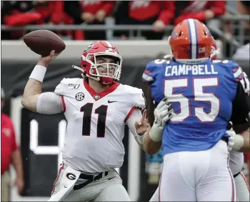  ?? JOHN RAOUX — THE ASSOCIATED PRESS ?? Georgia’s Jake Fromm, left, throws a pass over Florida defensive lineman Kyree Campbell during Saturday’s SEC battle. Fromm passed for 279yards and two touchdowns as the Bulldogs beat the Gators for the third straight year.