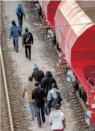  ??  ?? ON TRACK: Migrants head to Eurotunnel in Calais