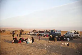  ??  ?? MOSUL: Iraqis who fled fighting between Iraqi forces and Islamic State militants wait next of their pickups to cross to the Kurdish areas through a sand barrier created by Kurdish forces to demarcate their border, in the Nineveh plain, northeast of...