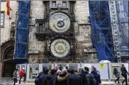  ?? PETR DAVID JOSEK / AP ?? Tourists stand in front of Prague’s famed Astronomic­al Clock, the Orloj, in the city’s Old Town on Jan. 8. The clock installed on the City Hall’s tower in 1410 will be completely disassembl­ed and taken for its first comprehens­ive restoratio­n since...